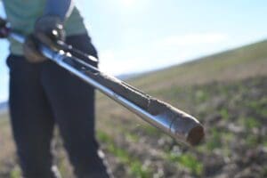 a person holding a soil probe towards the camera.