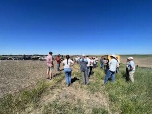 A group of people standing on a dirt field.