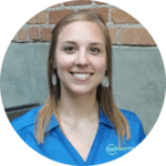 A woman in a blue shirt smiling in front of a brick wall, promoting a compost program.