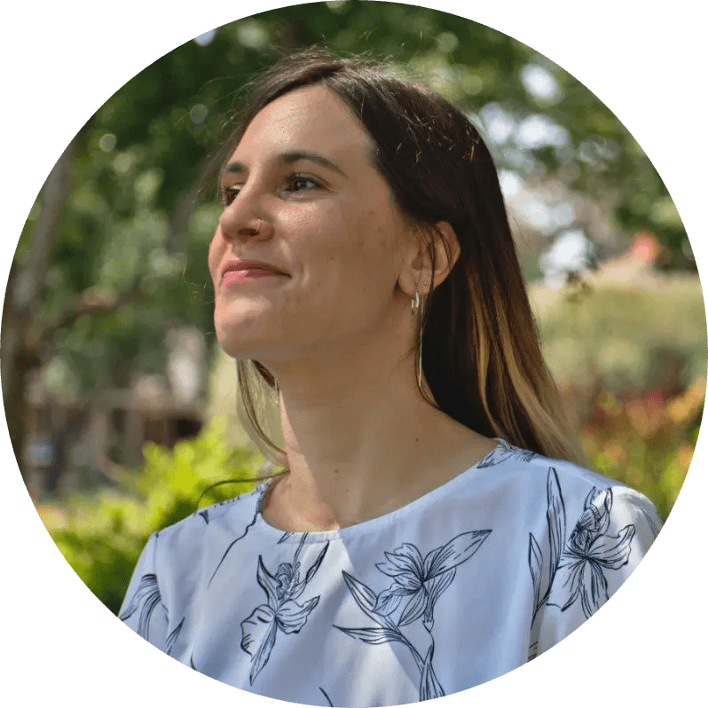A woman in a floral shirt standing in a park, contemplating soil carbon policies.