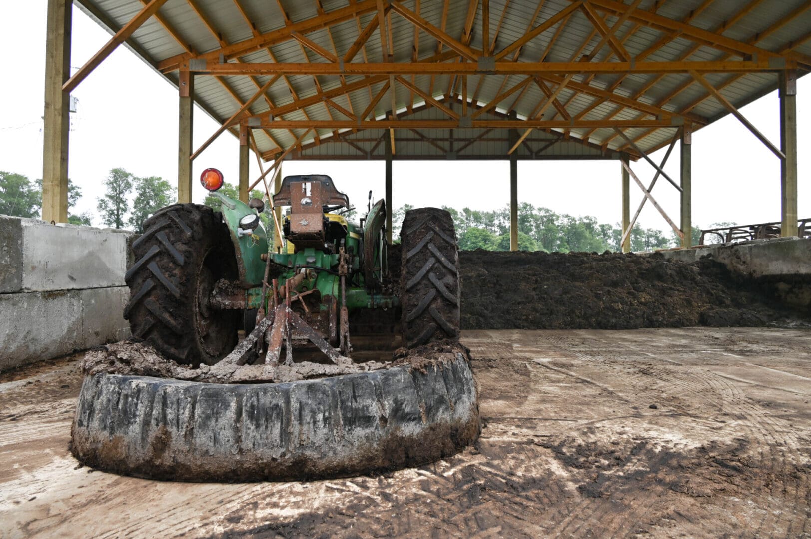 A tractor in a manure storage building.