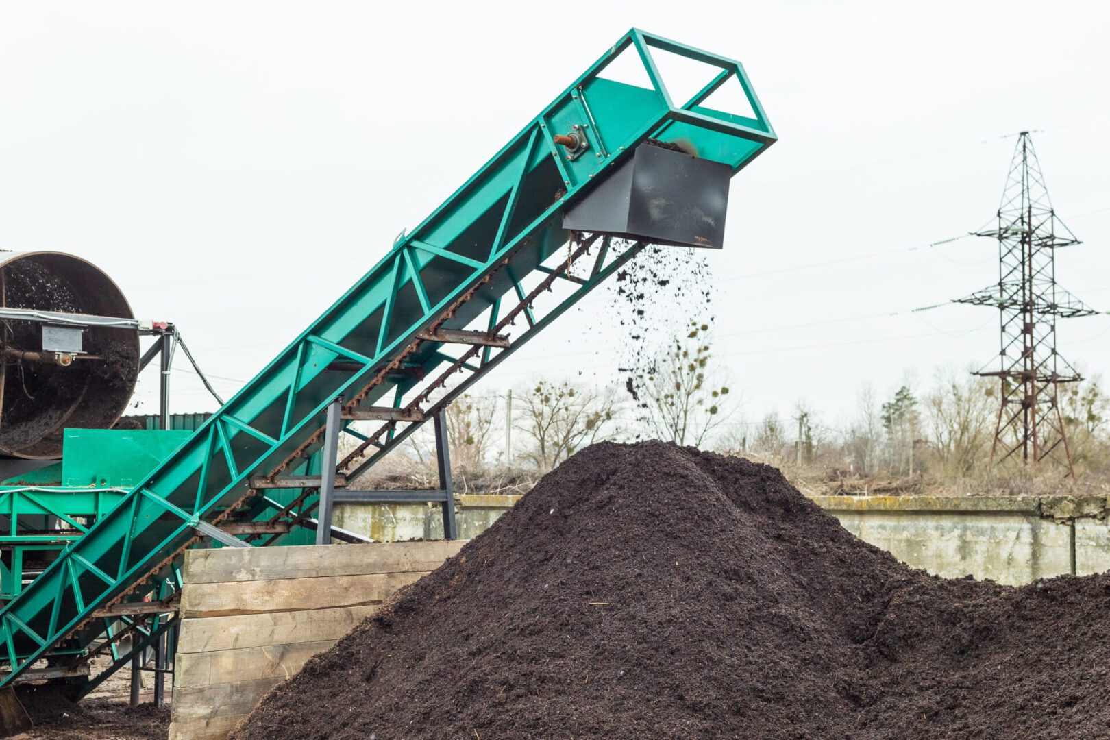 Producing soil at industrial compost plant. Sifting soil with a machinery to make clean earth ready to be used