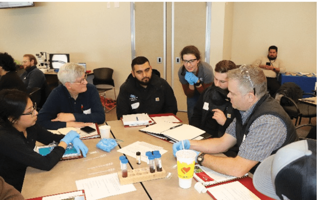 A group of SoilCon attendees sit around a table doing a collaborative hands-on activity together.