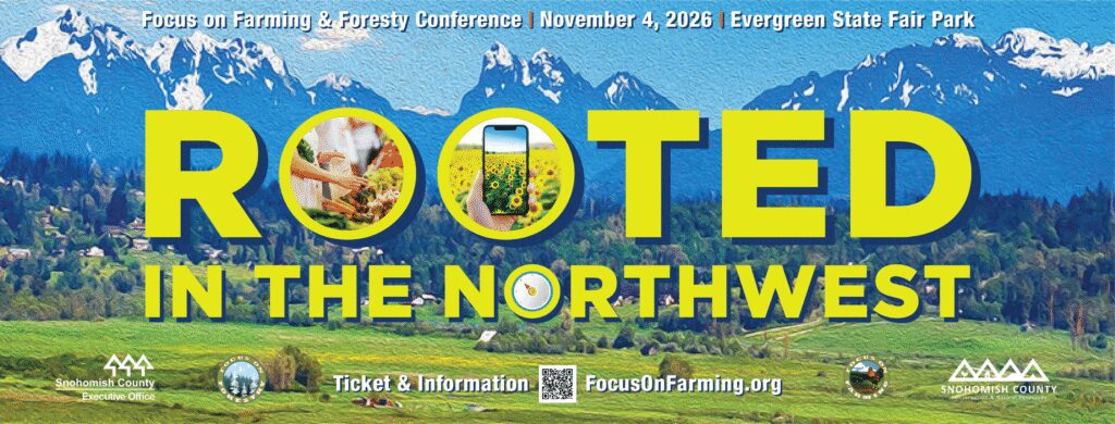 Alt text: Promotional banner for the Focus on Farming & Forestry Conference. A panoramic landscape of green farmland and a rural community sits in front of snow-capped mountains under a blue sky. Large yellow text reads “ROOTED IN THE NORTHWEST.” The two “O” letters in “ROOTED” contain photos of harvested vegetables and a smartphone displaying a sunflower field. A compass graphic appears within the word “NORTHWEST.” Text at the top reads: “Focus on Farming & Forestry Conference | November 4, 2026 | Evergreen State Fair Park.” At the bottom, logos for Snohomish County and Focus on Farming & Forestry flank the text “Ticket & Information” and the website “FocusOnFarming.org,” alongside a QR code.